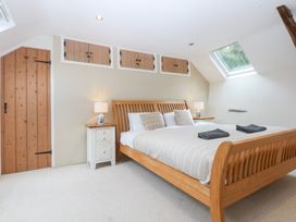 A bedroom with a bed and bedside table at Ty Newydd Llanrhychwyn near Llanrwst