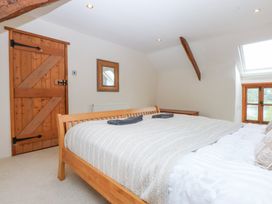 A bedroom with a bed and wooden door at Ty Newydd Llanrhychwyn near Llanrwst