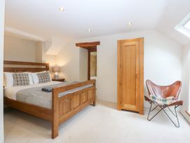 A bedroom with a wooden bed and a dresser at Ty Newydd in Llanrhychwyn near Llanrwst
