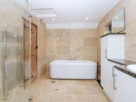 A bathroom with a bath tub and shower at Ty Newydd in Llanrhychwyn near Llanrwst