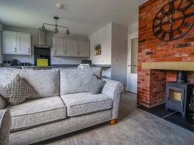 A living room with a sofa and kitchen in Dan’s Holiday Cottage in Driffield