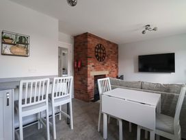 A living room with a television and seating area at Dan's Holiday Cottage in Driffield
