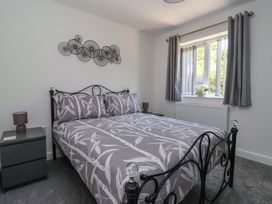 A bedroom with a bed and bedside table at Dan’s Holiday Cottage in Driffield