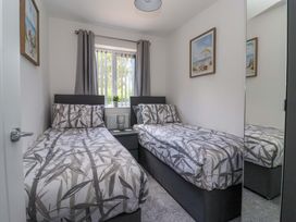 A bedroom with two beds and a window at Dan’s Holiday Cottage in Driffield