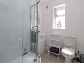 A bathroom with shower, toilet, sink and towel rack at Dan’s Holiday Cottage in Driffield