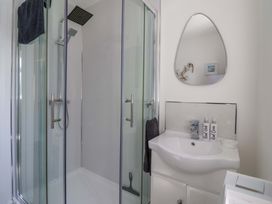 A bathroom with a shower and vanity sink at Dan’s Holiday Cottage in Driffield
