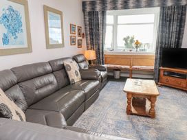 A living room with a sofa and a coffee table at King Arthur Suite in Trearddur Bay