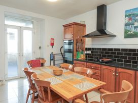 A kitchen with a dining table and chairs at King Arthur Suite Trearddur Bay