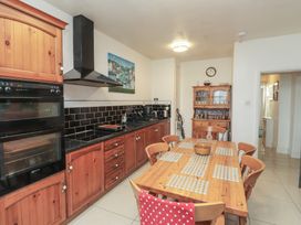 A kitchen with a table and chairs at King Arthur Suite in Trearddur Bay