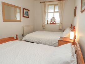 A bedroom with two beds and a mirror at King Arthur Suite in Trearddur Bay