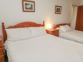 A bedroom with a double bed and a single bed at King Arthur Suite, Trearddur Bay