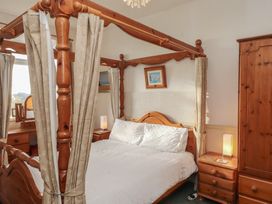 A bedroom with a four-poster bed and bedside tables at King Arthur Suite Trearddur Bay