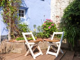 Two chairs in a garden near flowers at Carpenters Cottage in Okehampton