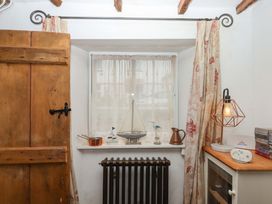 A room with a window, curtain, radiator, and decor at Carpenters Cottage in Okehampton