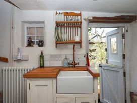 A kitchen with a wooden countertop and a sink at Carpenters Cottage Okehampton