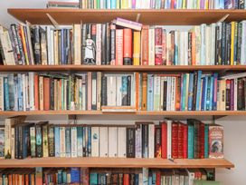 A bookshelf filled with various books at Carpenters Cottage Okehampton