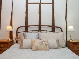 A bedroom with a bed and bedside lamps at Carpenters Cottage in Okehampton