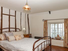 A bedroom with a bed and window at Carpenters Cottage Okehampton