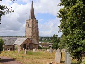 A church with a graveyard and tombstones at Carpenters Cottage in Okehampton