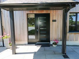 An entrance with a front door and flowers at Just A Cottage in St Florence