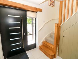 A hallway with a front door and staircase at Just A Cottage St Florence