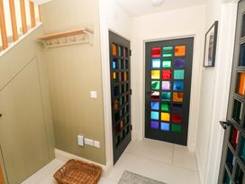 A hallway with colorful glass doors and wall hooks at Just A Cottage St Florence