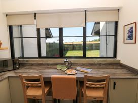 A kitchen with a counter, microwave, kettle, and two chairs at Just A Cottage St Florence