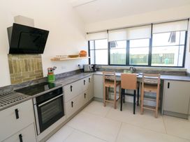 A kitchen with appliances and seating area at Just A Cottage St Florence