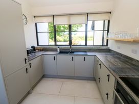 A kitchen with cabinets and a sink at Just A Cottage in St Florence