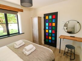 A bedroom with a bed, wardrobe, and colorful door at Just A Cottage in St Florence