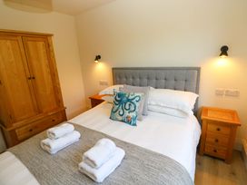 A bedroom with a bed and wardrobe at Just A Cottage in St Florence