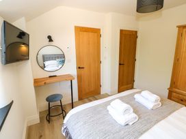 A bedroom with a bed and a mirror at Just A Cottage in St Florence