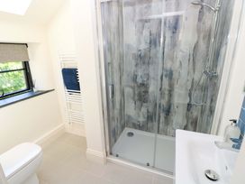 A bathroom with a shower, toilet, and sink at Just A Cottage in St Florence