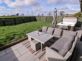 A garden with a seating area and hot tub at Just A Cottage, St Florence