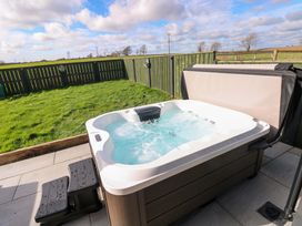 A hot tub with a step stool in an outdoor area at Just A Cottage St Florence