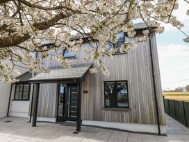A house with a wooden exterior and a flowering tree at Just A Cottage in St Florence