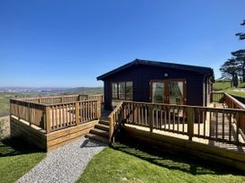 A lodge with a deck and steps at Lowena Lodge Whitsand Bay Holiday Park near Millbrook