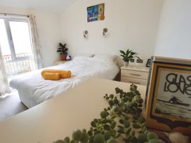 A bedroom with a bed and plant at Lowena Lodge Whitsand Bay Holiday Park near Millbrook