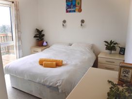 A bedroom with a bed and nightstands at Lowena Lodge Whitsand Bay Holiday Park near Millbrook