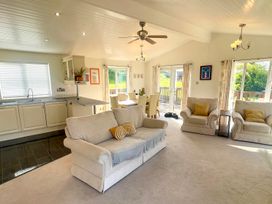 A living room with a sofa and dining area at Lowena Lodge Whitsand Bay Holiday Park near Millbrook