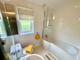 A bathroom with a bathtub, shower, and toilet at Lowena Lodge Whitsand Bay Holiday Park near Millbrook