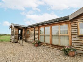 A wooden building with windows and a door at Owl Barn in Banbury