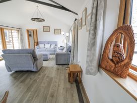 A living room with sofas and an owl sculpture at Owl Barn in Banbury