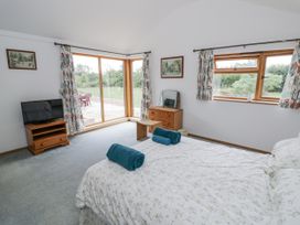 A bedroom with a bed and television at Owl Barn in Banbury
