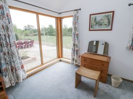 A bedroom with a dresser and mirror at Owl Barn in Banbury