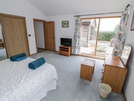 A bedroom with a bed and television at Owl Barn in Banbury