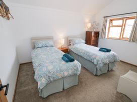 A bedroom with two single beds and a chest of drawers at Owl Barn in Banbury