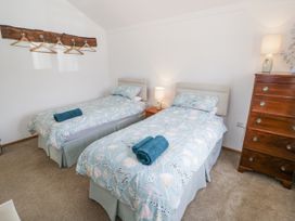 A bedroom with two beds and a dresser at Owl Barn in Banbury