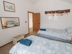 A bedroom with twin beds and a mirror at Owl Barn in Banbury
