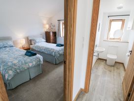 A bedroom with two beds and an adjoining bathroom at Owl Barn in Banbury